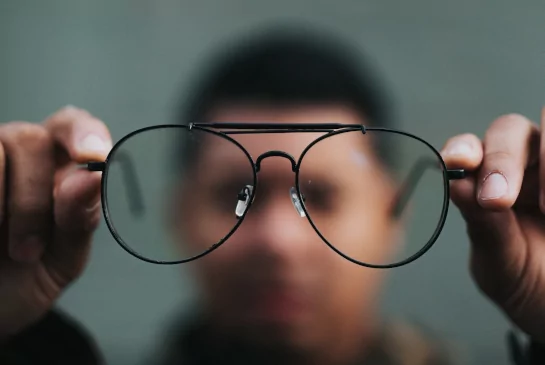 Man holding eyeglasses